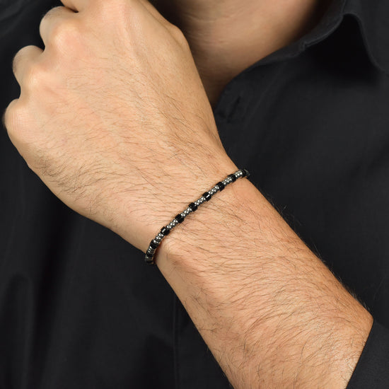 PULSERA DE ACERO PARA HOMBRE CON ELEMENTOS PLATEADOS Y PIEDRAS NEGRAS