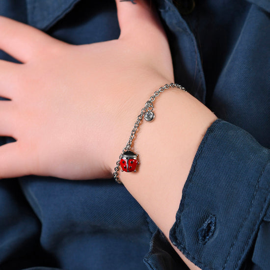 PULSERA DE ACERO PARA NIÑA CON MARIQUITA ESMALTADA EN ROJO Y NEGRO Y CRISTAL