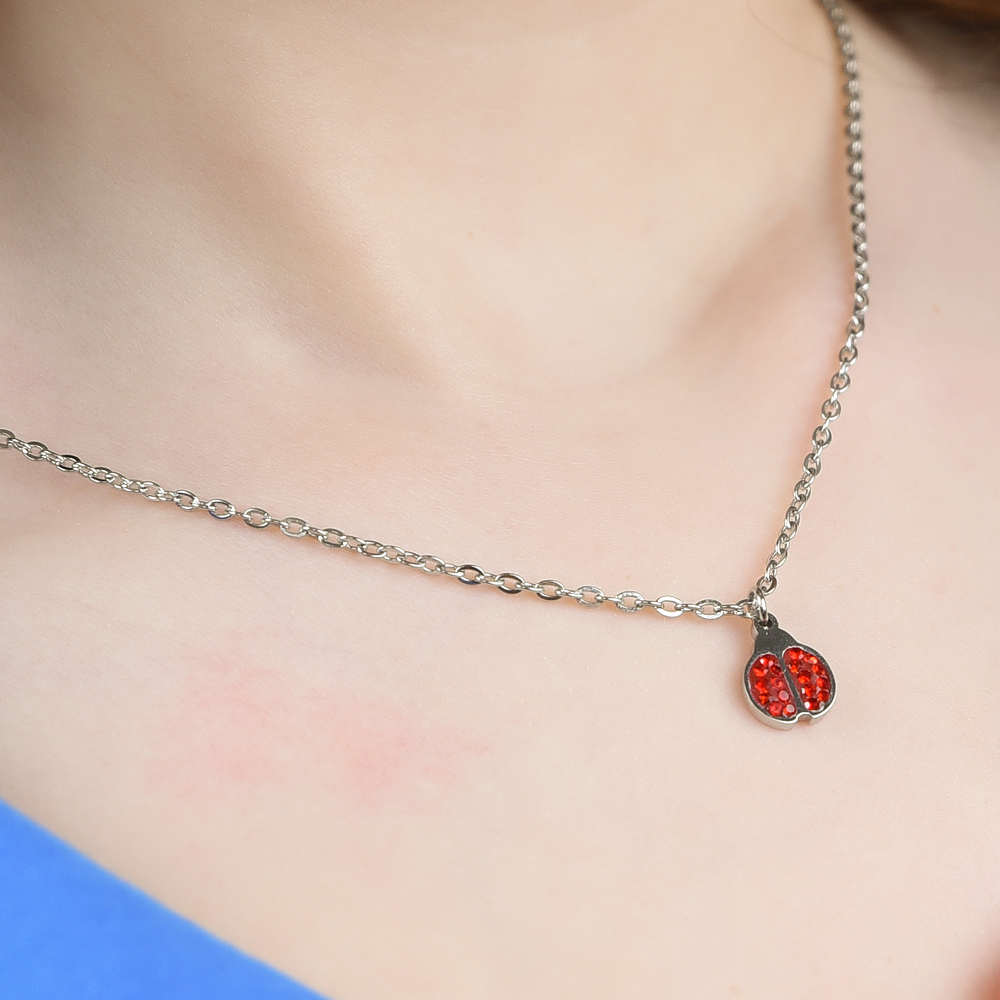 COLLAR DE NIÑA DE ACERO CON MARIQUITA Y CRISTALES ROJOS