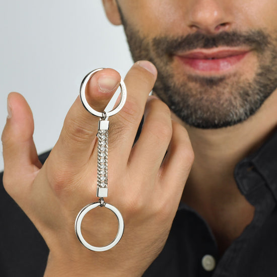 ELEMENTO LLAVERO DE HOMBRE DE ACERO CON CRISTALES BLANCOS